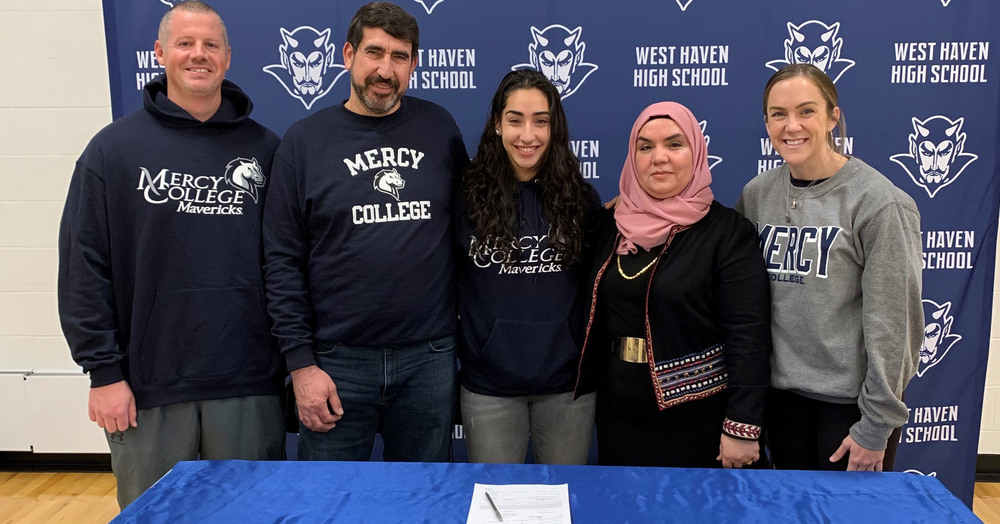 student, parents, and coaches posing