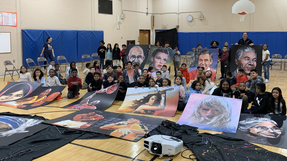 artist posing with students